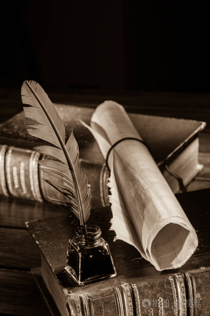 在木桌上的羽毛笔和卷纸莎纸, 旧书, 棕褐色效果