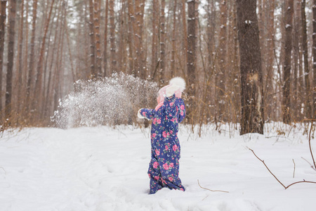 童年和人的概念女婴走在户外的冬天, 扔雪