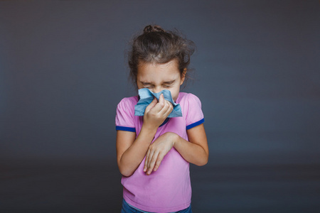 女孩关闭她的眼睛, 用手帕擤鼻涕照片