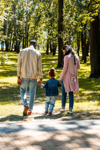 非洲裔美国人父母和女儿周末在公园散步的后视图
