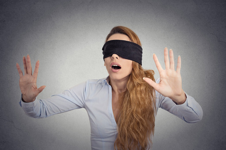 向前走用手蒙着眼睛的年轻女商人照片