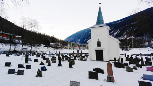 教堂墓地和木制教堂被雪覆盖着