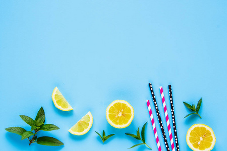 创意布局的柠檬片, 彩色稻草和薄荷叶在柔和的蓝色背景。夏季鸡尾酒和柠檬汁的配料。平躺, 顶部视图