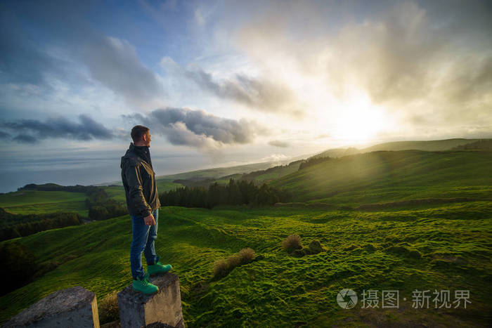 成功的男人仰望的夕阳的天空庆祝享受自由