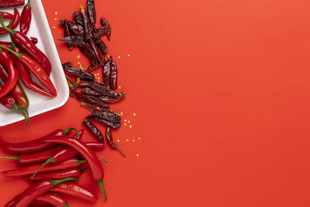 红辣椒和干中国辣椒在红色背景下的分离组