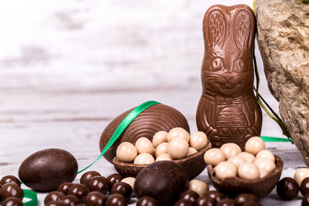 美味的巧克力复活节兔子和木制背景的鸡蛋。复制空间