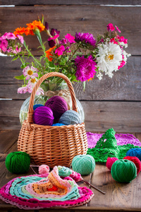 多色球的棉线钩针编织在一个木桌上的柳条篮和现成的多色螺纹针织餐巾, 选择性聚焦