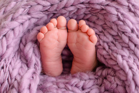 用毯子盖住新生婴儿脚的特写孩子们的腿特写镜头挂在房间里的沙发上.