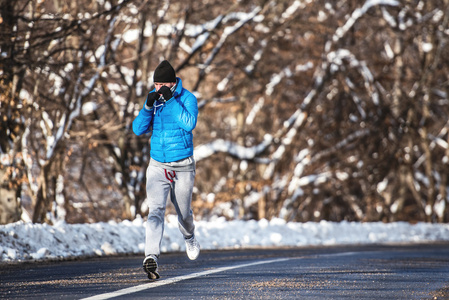 健壮的男人在森林道路上运行和体育训练。专业的慢跑者的户外锻炼