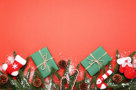 圣诞树分支与装饰和礼物箱子在红色背景