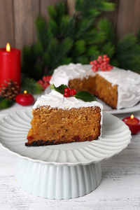 切片蛋糕覆盖奶油圣诞装饰在桌子上，对木墙背景