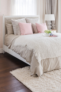 粉红色与白色托盘花在家里的床上的枕头