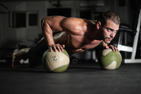 健身男人做俯卧撑的球, 锻炼生活方式的概念