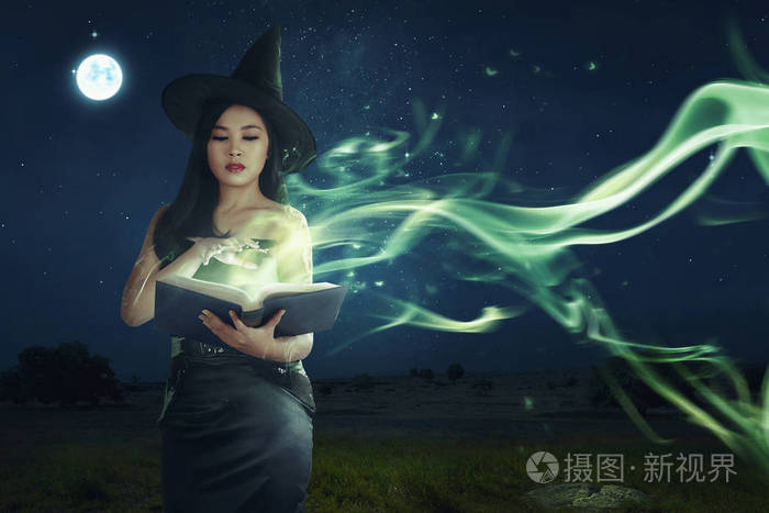 美丽的亚洲女巫从书本上学习魔术法术的夜晚