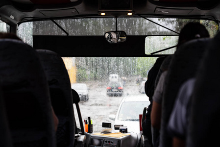 外面天气不好, 从里面到街道从窗口看, 公共汽车与乘客