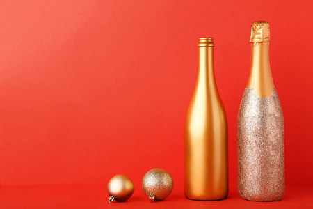 装饰的香槟酒瓶与红色背景上的圣诞小泡
