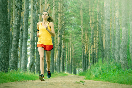 正在运行的女人。在公园慢跑的女跑步者。女孩在户外训练。在森林小径上锻炼。健康, 健身, 健康的生活方式。运动, 有氧运动, 锻炼