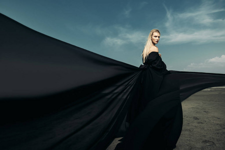 哥特美容一个美丽的哥特式女人的肖像, 穿着黑色长裙, 摆在户外.