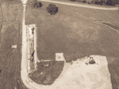 复古色调鸟瞰图一个工作 pumpjack 是在美国德克萨斯州的乡村 La 田庄的石油钻探现场抽水原油和水乳剂。旧的 pumpja