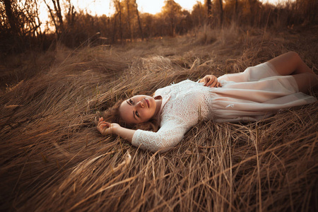 在夕阳背景下躺在田野上的女孩