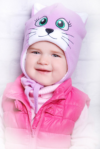 小女孩微笑着在温暖的帽子图片