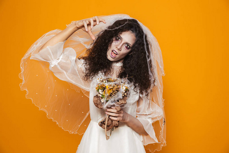 令人毛骨悚然的死新娘在白色婚纱看起来相机和可怕的孤立在橙色照片