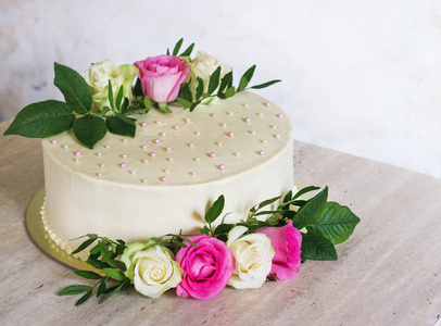 美丽的婚礼蛋糕与鲜花在大理石桌和白色背景
