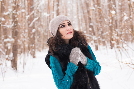 在冬天散步的快乐的年轻妇女。在雪的自然美丽的女孩