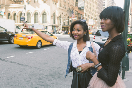 两个美丽的黑人女人叫出租车在纽约