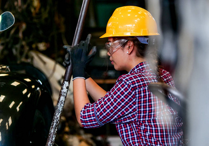 在工厂工作的年轻的亚洲工程师妇女与机器