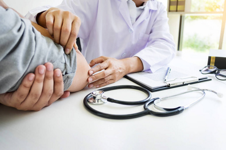 临床报告有吸引力的男性医生探讨推拿治疗背部疼痛患者的临床报告照片