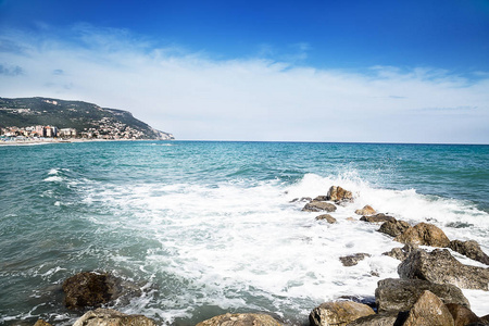 石头在海边。蔚蓝大海的丝质波浪。夏季海滩背景。意大利, 德国