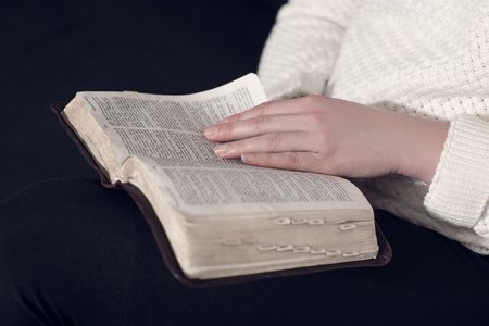 一个女人读圣经 》 的特写照片
