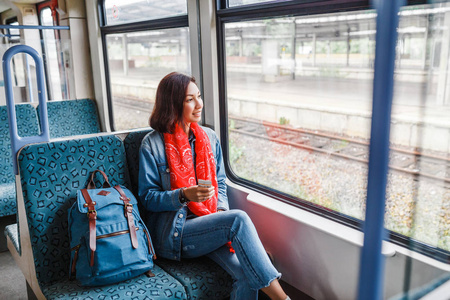 带背包的亚洲女士在火车上旅行图片