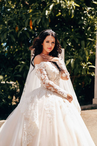 时尚户外照片美丽的新娘与深色的头发在豪华婚纱摆在优雅的别墅