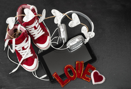 爱音乐概念。红色运动鞋 耳机 平板电脑和 hea