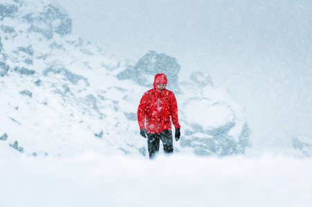 冰雪覆盖的道路上, 穿着红色大衣的男子走在雪地上