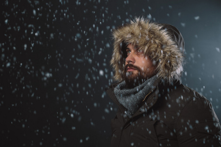 英俊的男人,在暴风雪中照片