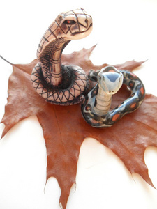 在白色背景上的两个装饰陶瓷蛇