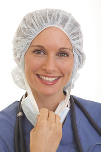 微笑的年轻女医生的画像在擦洗拉扯面具