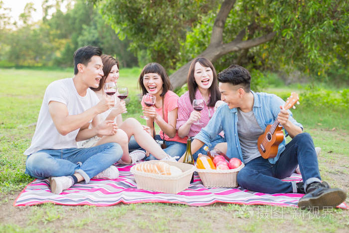 朋友微笑愉快享用红酒在野餐
