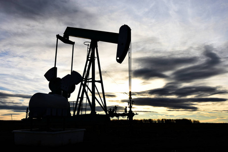 一个工作的石油和天然气工业泵杰克在日落的剪影图像