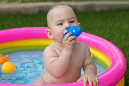 一个小孩子在游泳池里洗澡, 夏天充气儿童充气池。