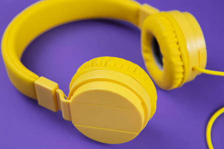 蓝色背景上的黄色耳机。音乐理念