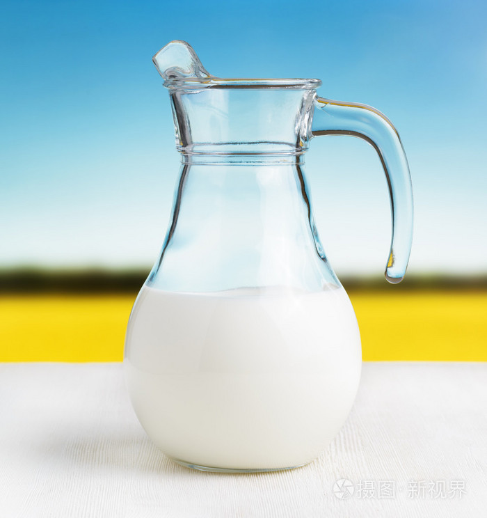 罐牛奶草甸背景上半满满的水罐
