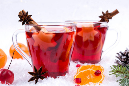 传统的热饮料在圣诞节的时候。圣诞热红酒配香料和水果。白雪背景