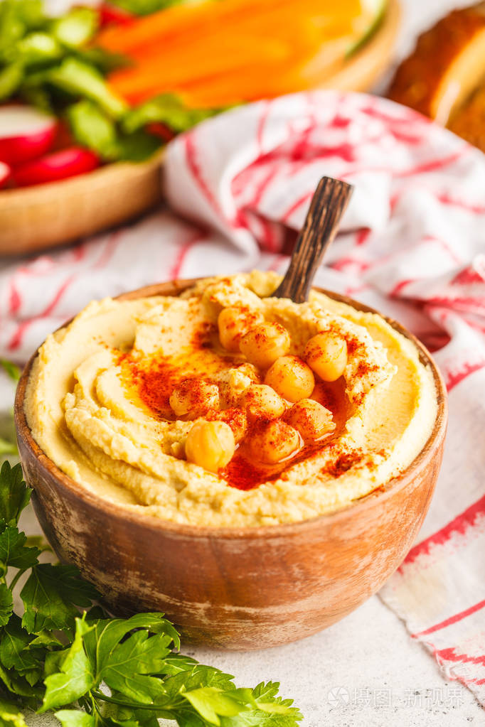 经典鹰嘴豆泥在木碗蔬菜