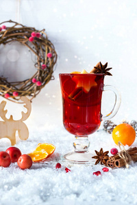 白雪背景下的圣诞热酒配橙子和香料