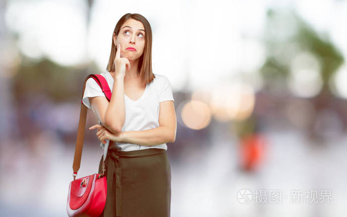 年轻漂亮的女人与困惑和周到的外观, 看着侧身, 思考和疑惑之间的不同