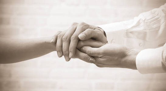 医生安慰她女性病人的手照片